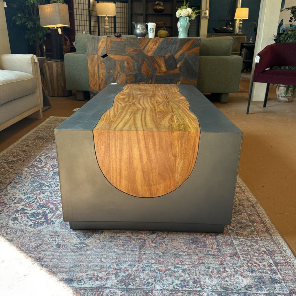 Modern coffee table with wooden top and gray base in a living room setting