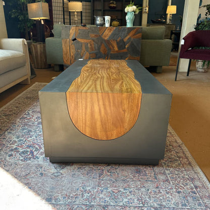 Modern coffee table with wooden top and gray base in a living room setting