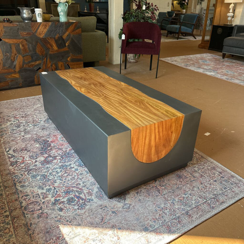 Modern furniture piece with wooden top and gray base on a patterned rug