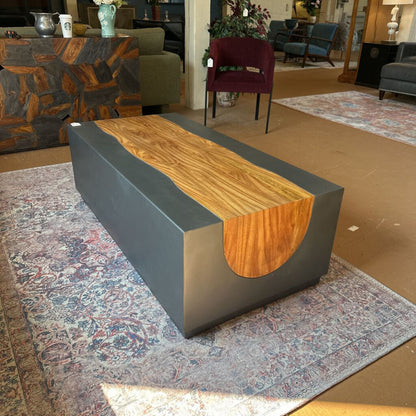 Modern furniture piece with wooden top and gray base on a patterned rug