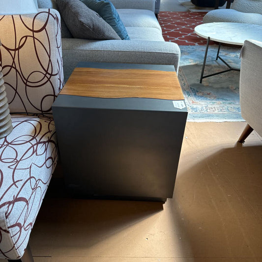 Modern living room with a gray sofa, wooden coffee table, and patterned rug.