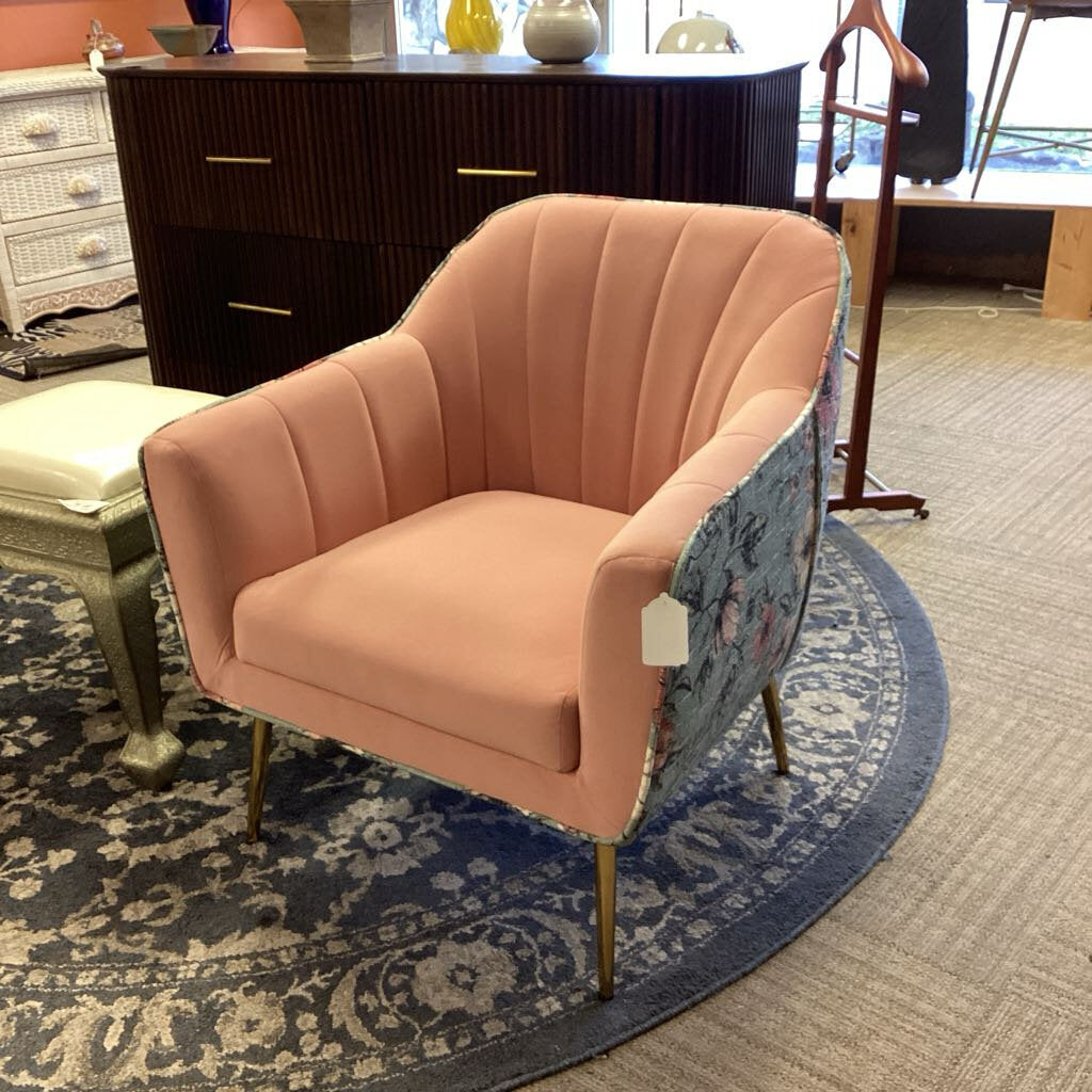 Pink armchair on a patterned rug in an indoor setting
