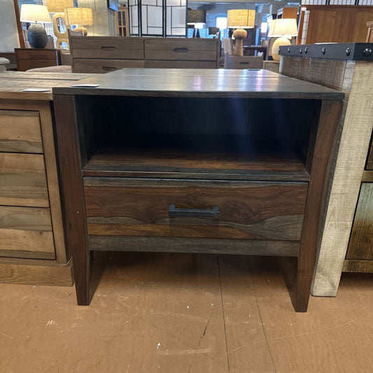 Wooden nightstand with a metal top in a furniture store setting