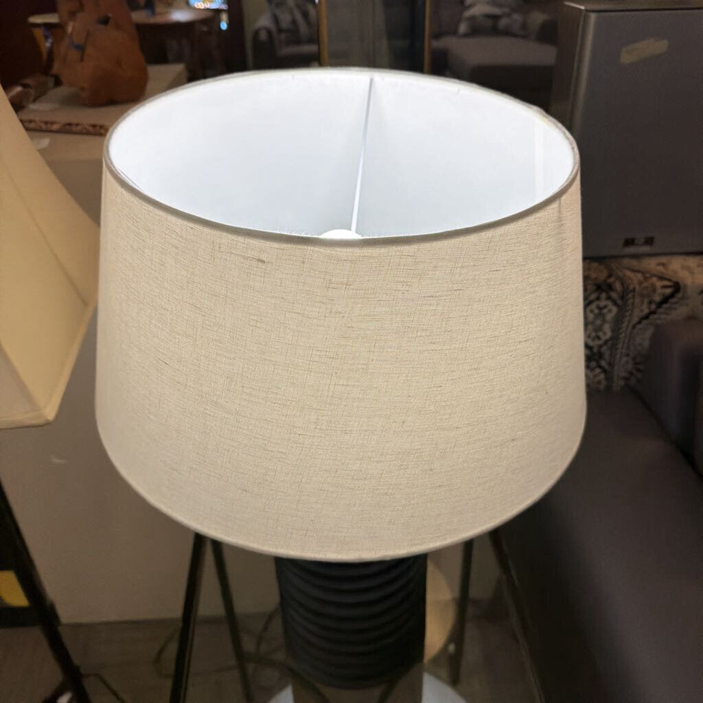 Beige lampshade on a stand in an indoor setting
