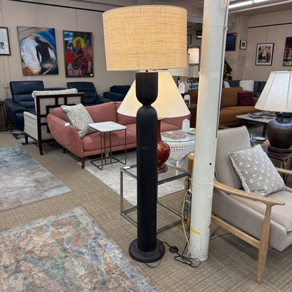 Living room with furniture and decor including a lamp and couch.