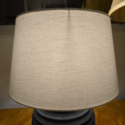 Textured beige lampshade on a wooden surface