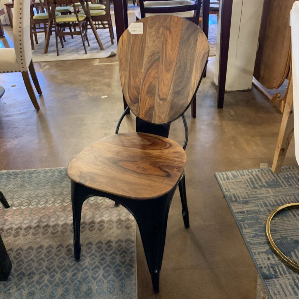 Wooden chair with black metal legs in a store setting