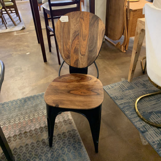 Wooden chair with black metal legs in a showroom setting