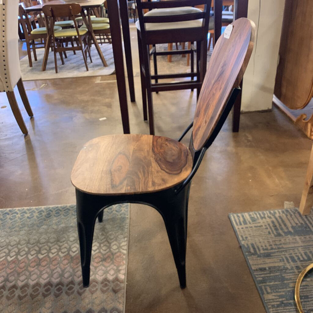 Wooden chair with black metal frame in a store setting