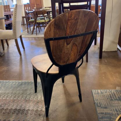 Wooden chair with black metal frame in a showroom setting