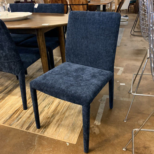 Blue upholstered chair in a showroom setting with other furniture.
