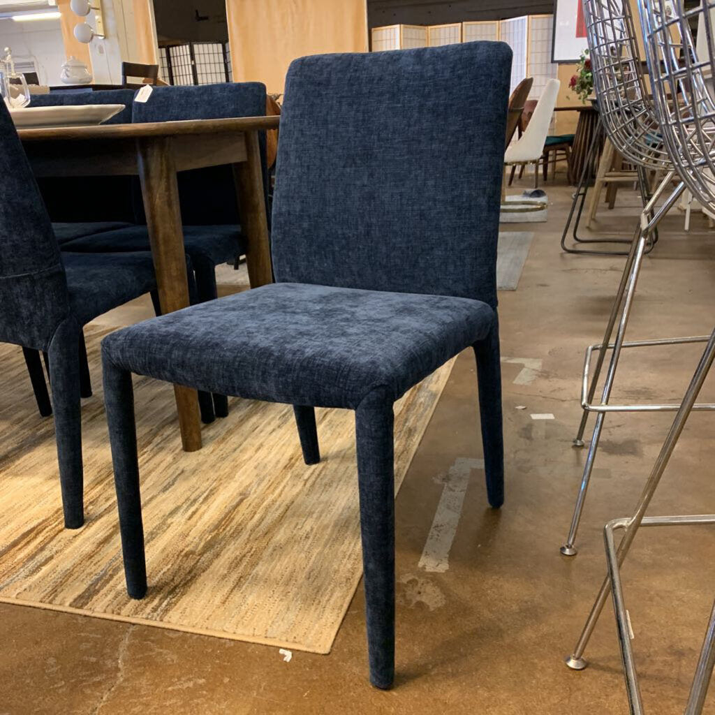 Blue upholstered chair in a showroom setting with other furniture.