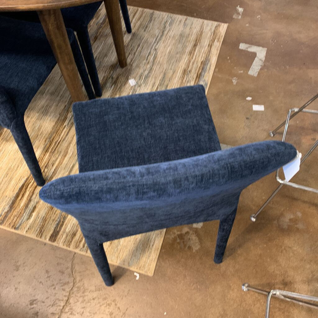 Blue chair on a wooden floor with other furniture partially visible
