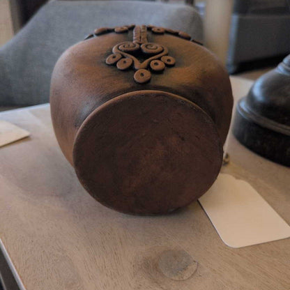 Wooden container with decorative lid on a wooden surface