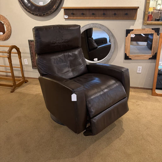 Brown leather recliner chair in a showroom setting with mirrors and shelves.
