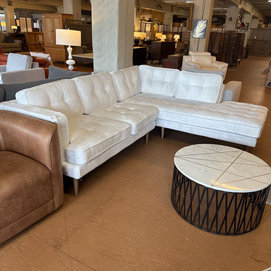 Sectional sofa in a showroom with a coffee table and other furniture.