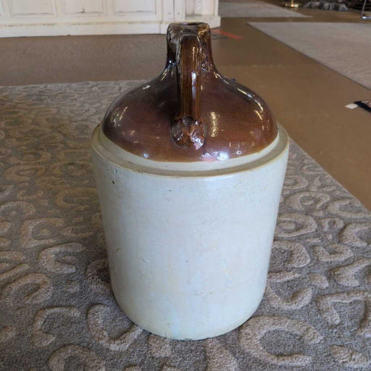 Ceramic jar with brown top on a textured surface