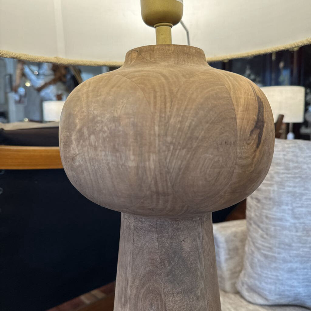 Wooden lamp with a textured finish in a blurred indoor setting