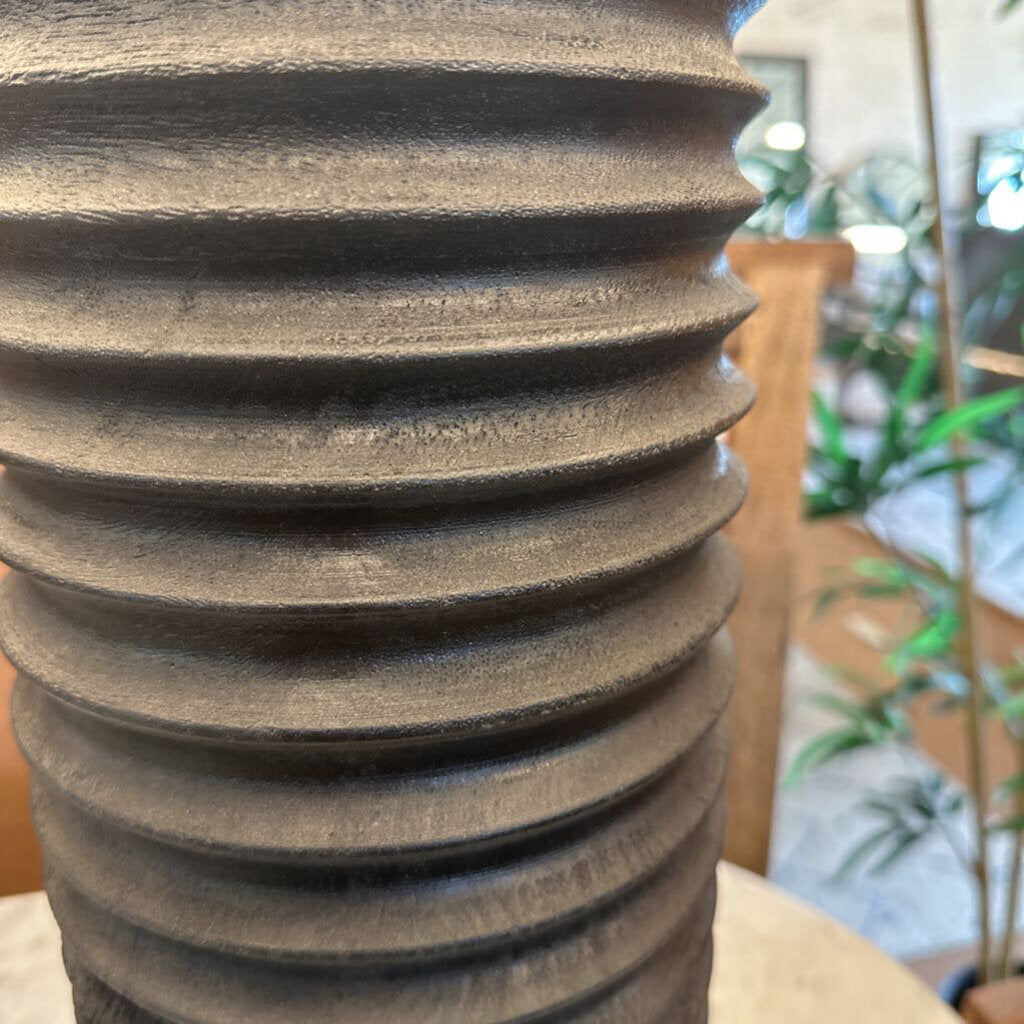 Close-up of a textured vase with blurred indoor background