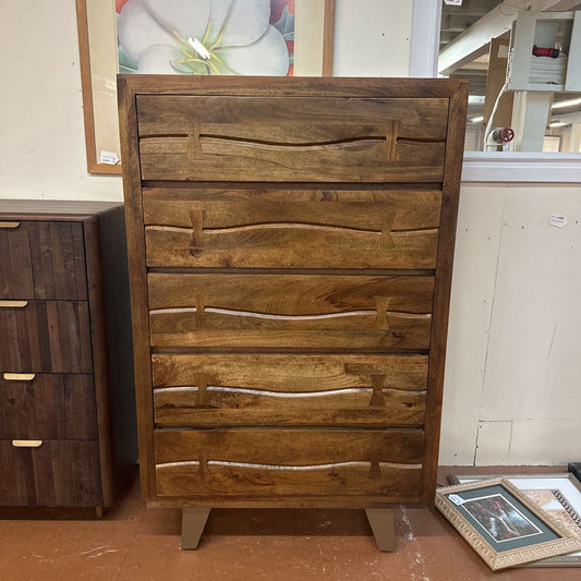 Wooden dresser with wavy design in a store setting