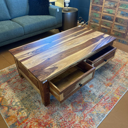 Wooden coffee table with drawers in a living room setting