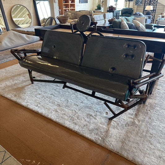 Black metal bench in a living room setting with furniture and decor in the background