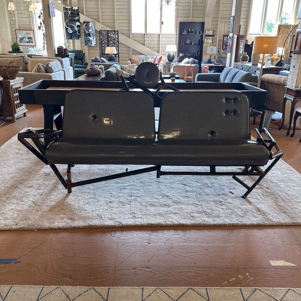 Black metal bench in a room with wooden floors and furniture