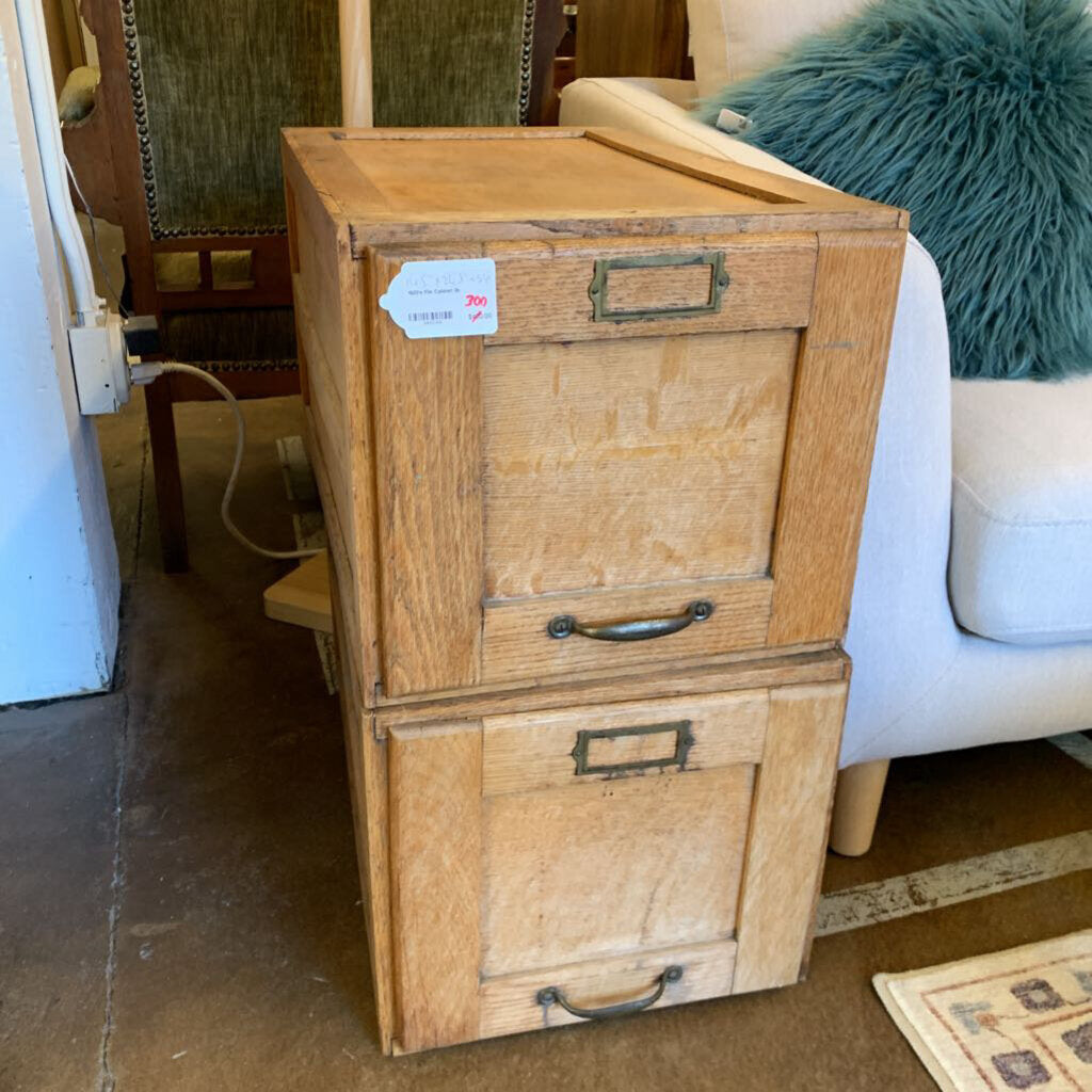 Wooden file cabinet with two drawers in a room setting.
