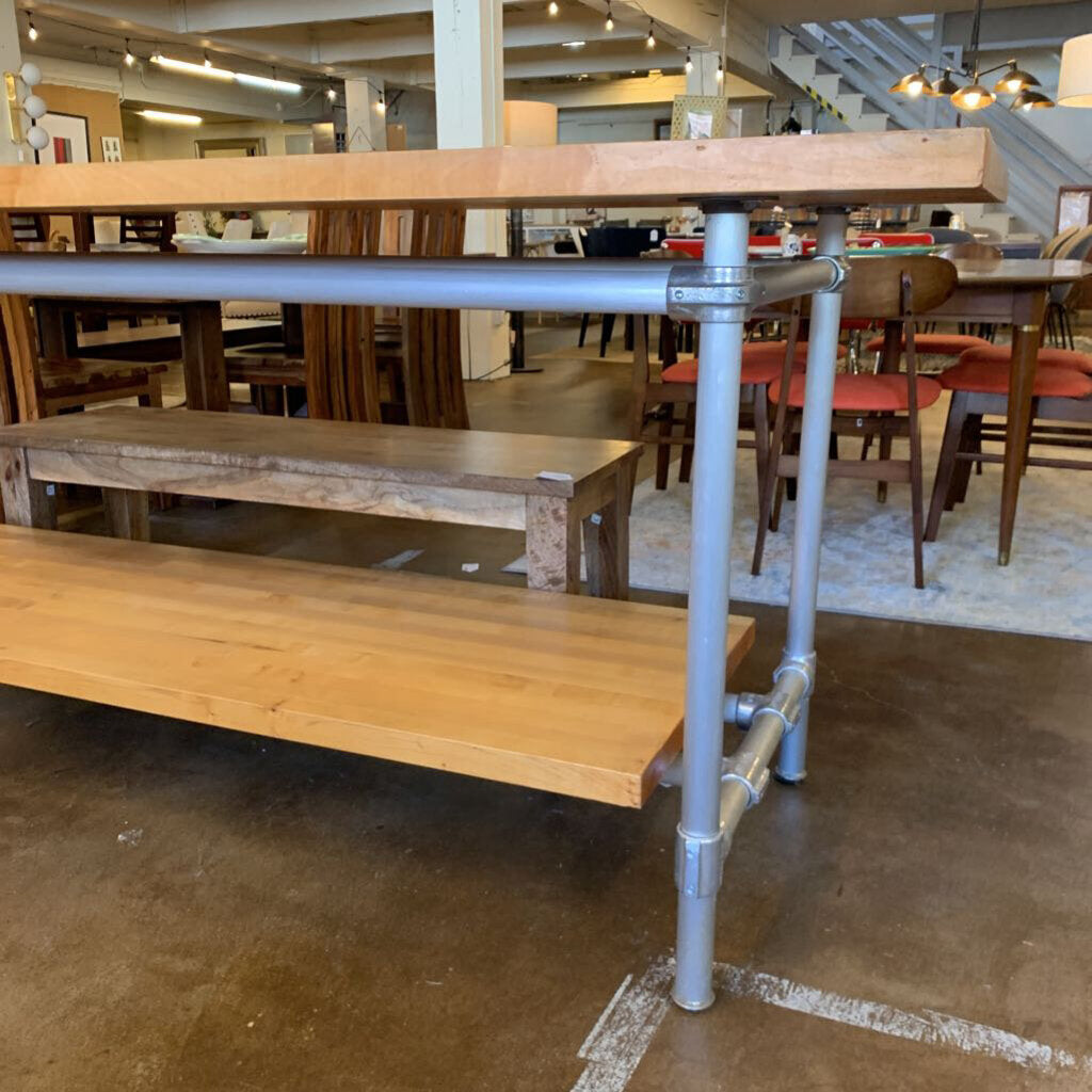 Wooden table with metal legs in a room with other furniture