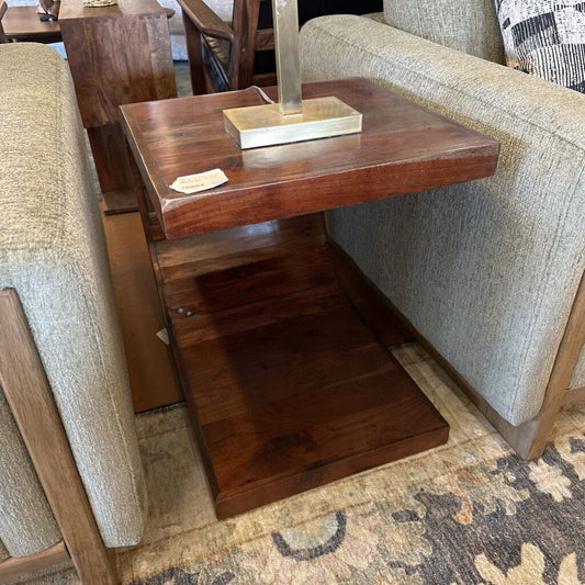 Wooden side table against a sofa with a patterned rug underneath