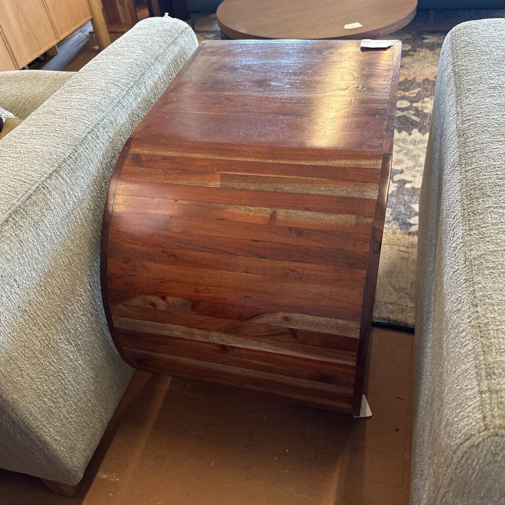 Wooden side table between two beige couches in a room setting