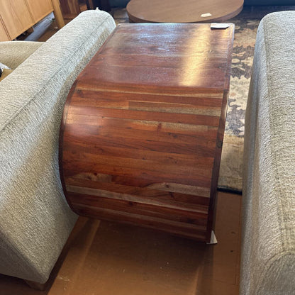 Wooden side table between two beige couches in a room setting