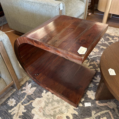 Wooden coffee table with a textured surface on a patterned rug