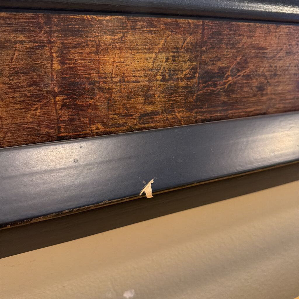 Close-up of a wooden surface with a metal strip, possibly a part of a vehicle or furniture.