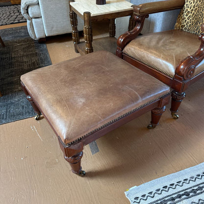 Brown leather ottoman and chair in a room with wooden floor and furniture.