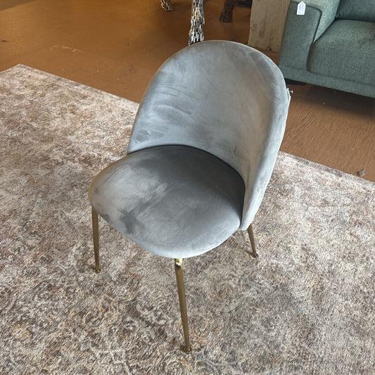 Gray chair with gold legs on a textured rug