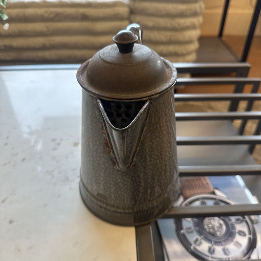 Metallic coffee pot on a kitchen counter with a blurred background