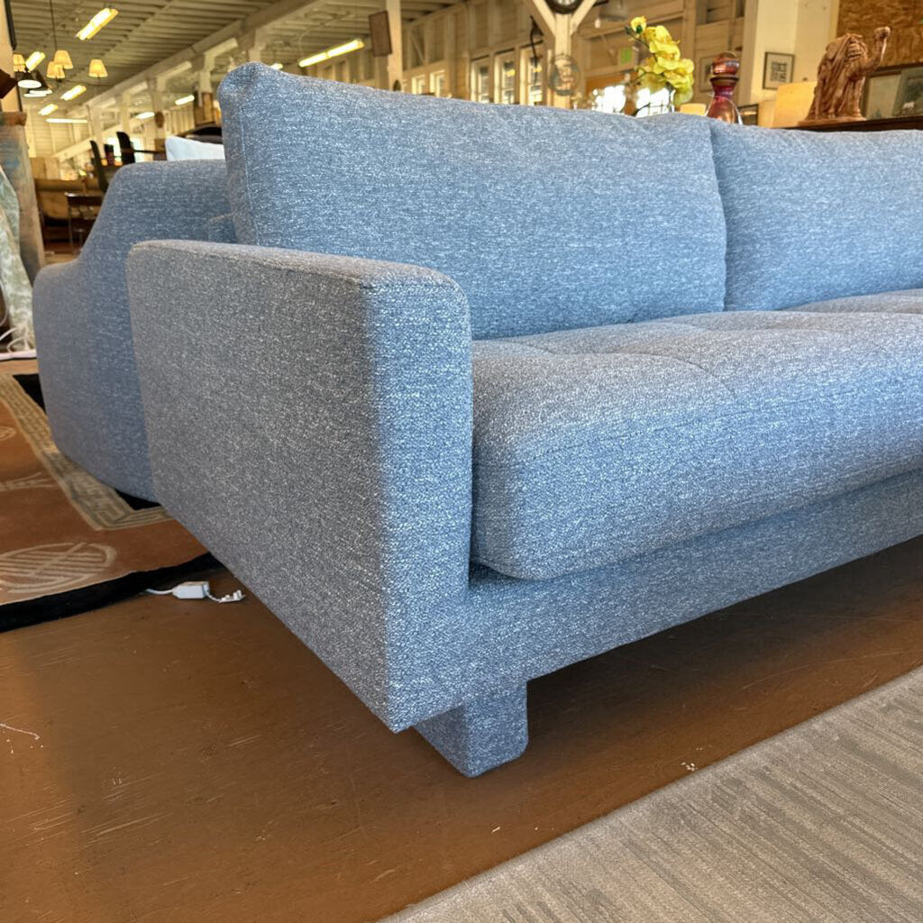 Blue sofa in a store setting with various items in the background