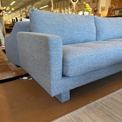 Blue sofa in a store setting with various items in the background