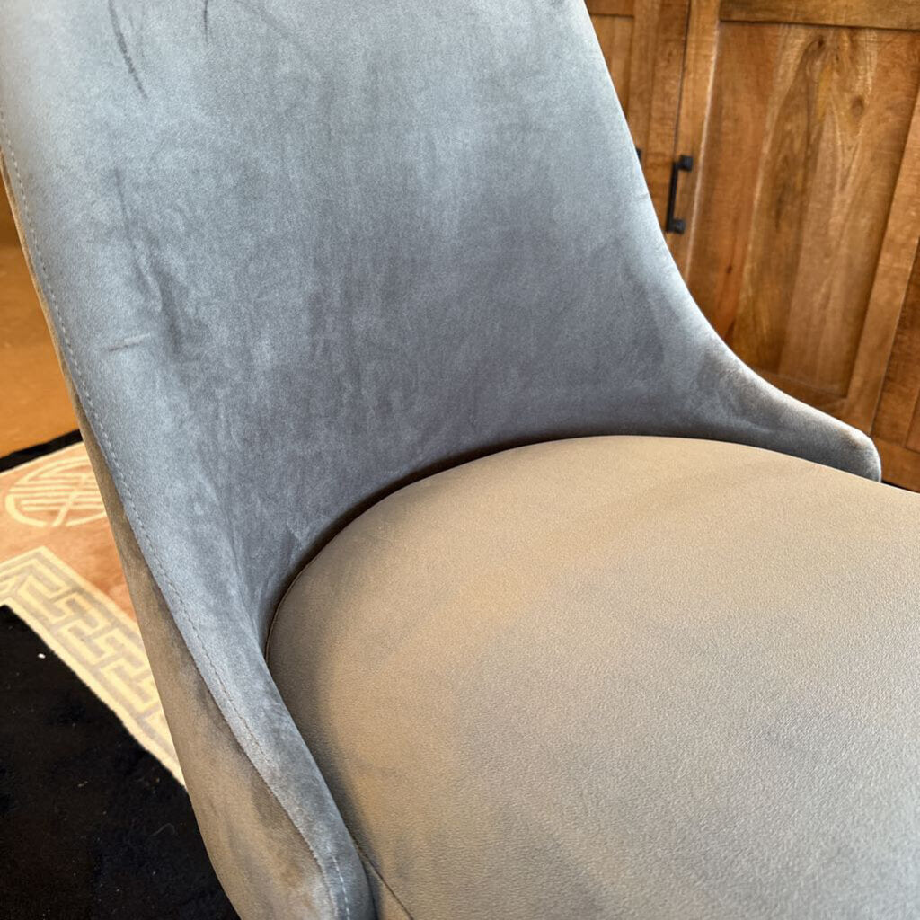 Gray upholstered chair with a wooden floor background