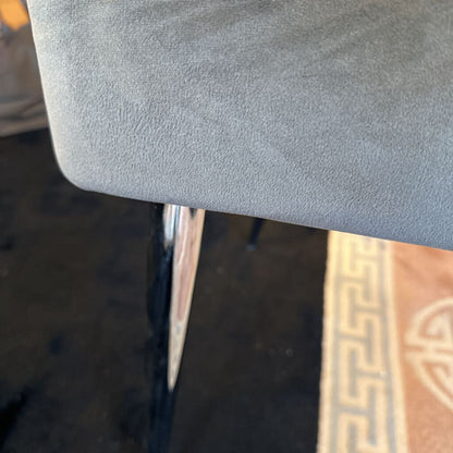 Close-up of a gray cushioned chair with a blurred background