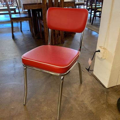 Red chair with metal legs in a room with tables and chairs