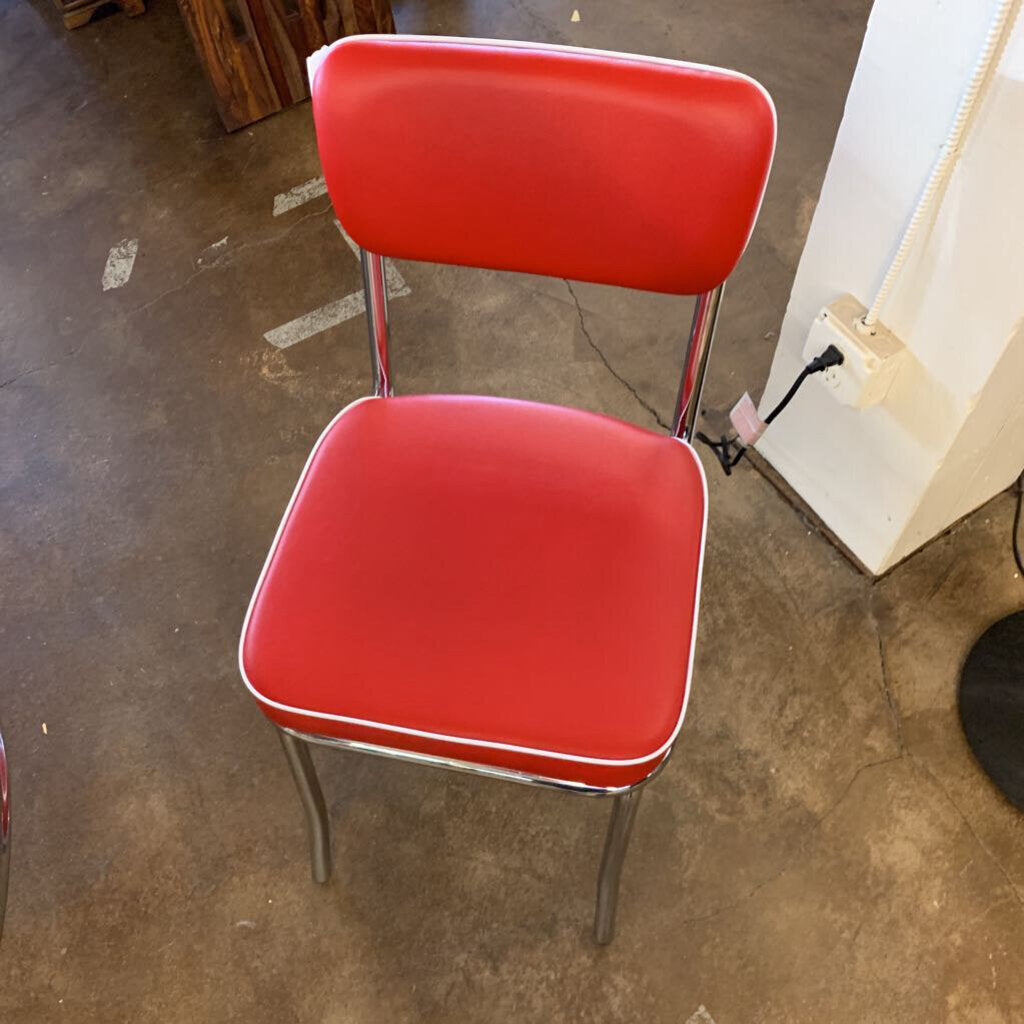 Red chair with a metal frame on a concrete floor.