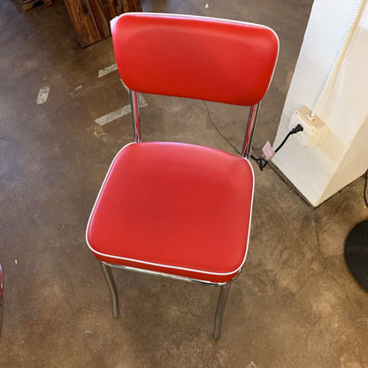 Red chair with a metal frame on a concrete floor.