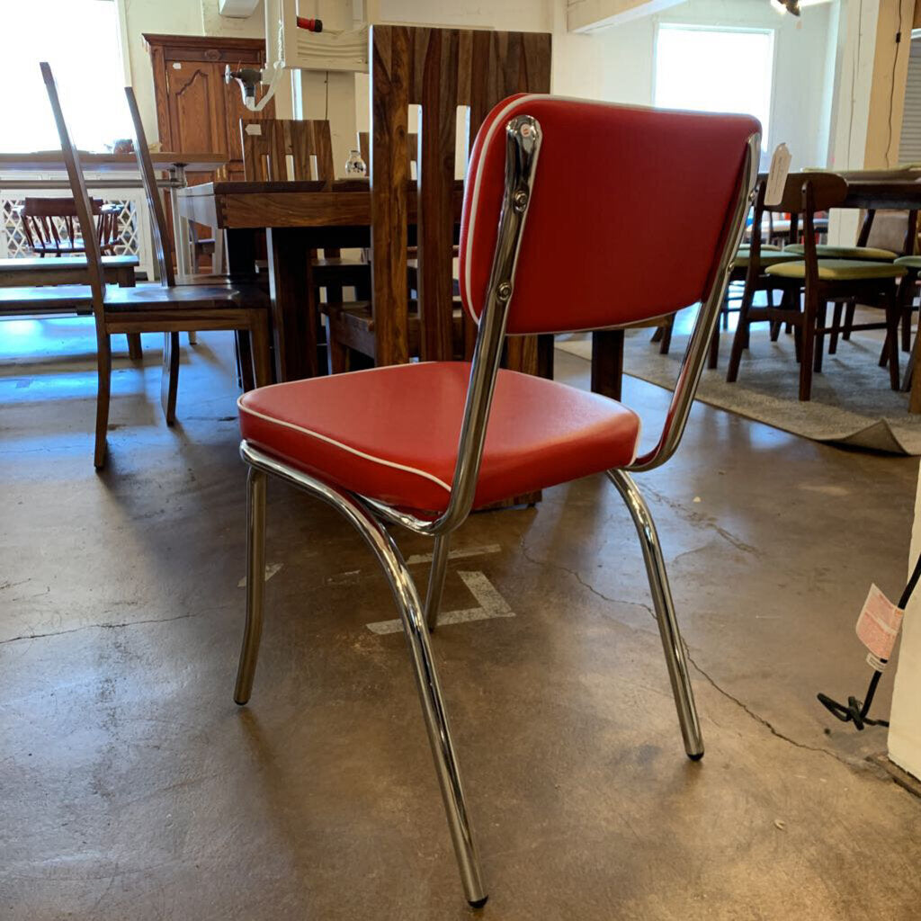 Red chair with chrome frame on a concrete floor in a store setting