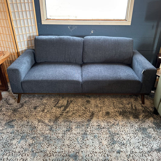 Gray sofa in a room with a patterned rug and window