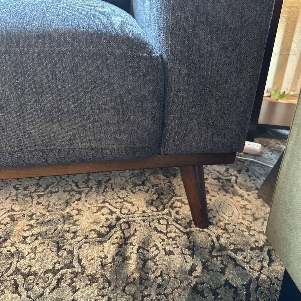 Blue upholstered chair on a patterned rug