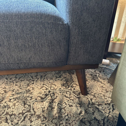 Blue upholstered chair on a patterned rug