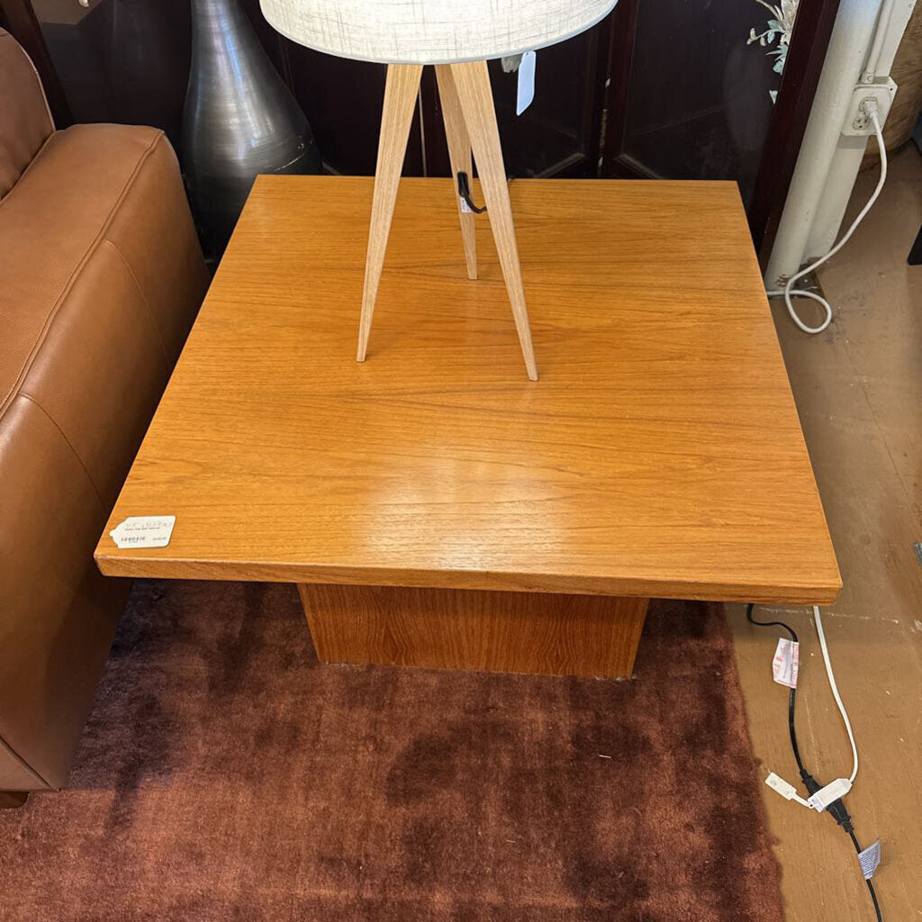 Wooden side table with a lamp on top in a room setting