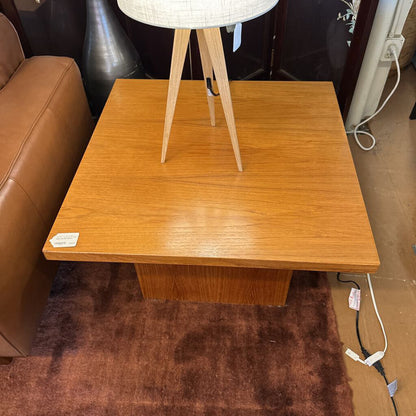 Wooden side table with a lamp on top in a room setting